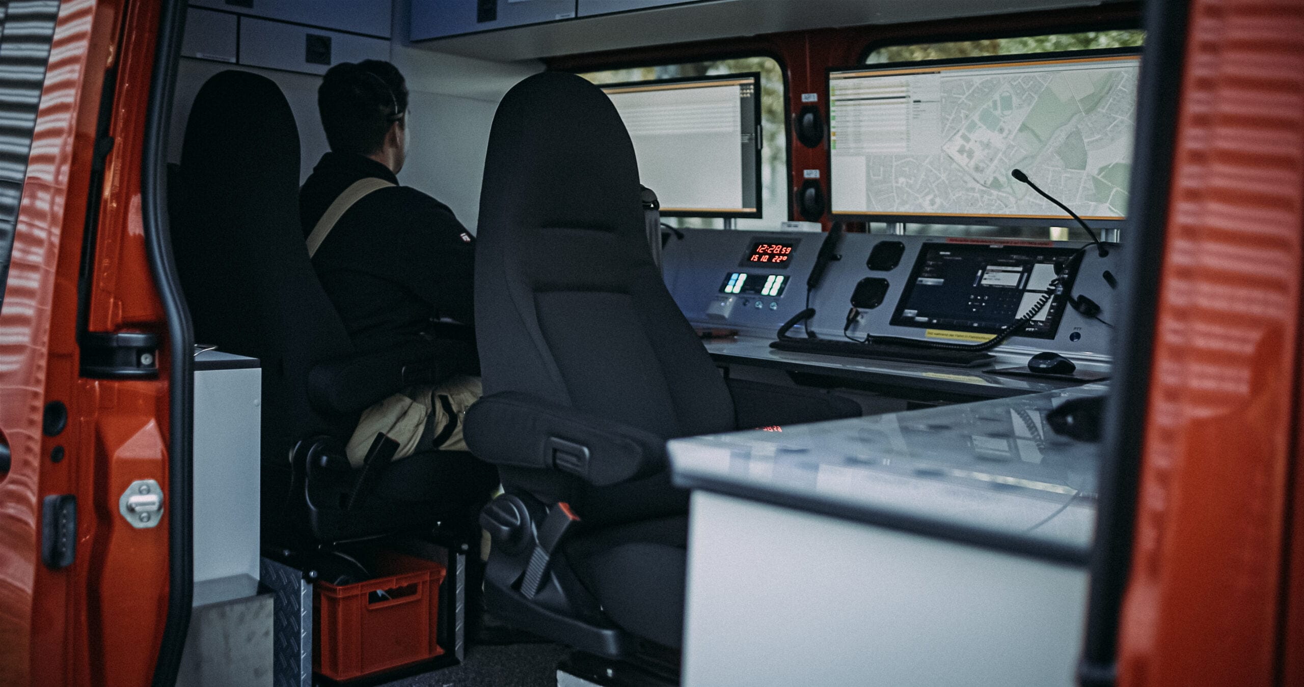 Feuerwehrmann an Computern im Einsatzleitwagen bei der Dokumentation